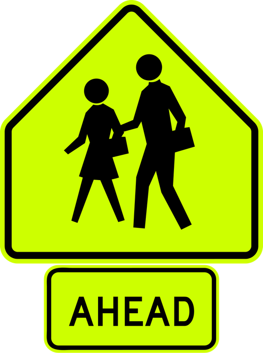School Crossing Ahead sign: fluorescent yellow-green five-sided sign with two children walking, above an AHEAD plaque.